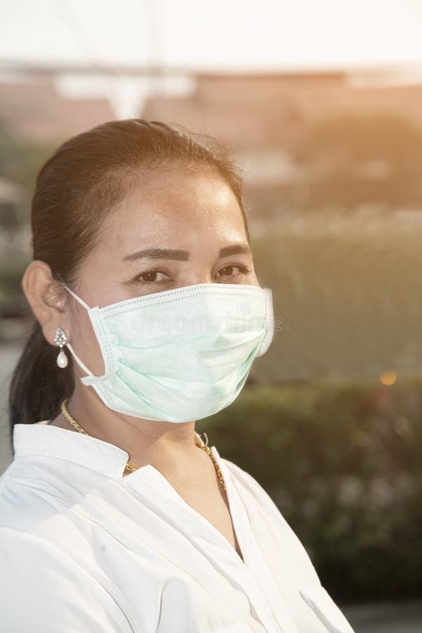 Asian woman wear a Corona Virus and minute dust protection mask standing at the market area.