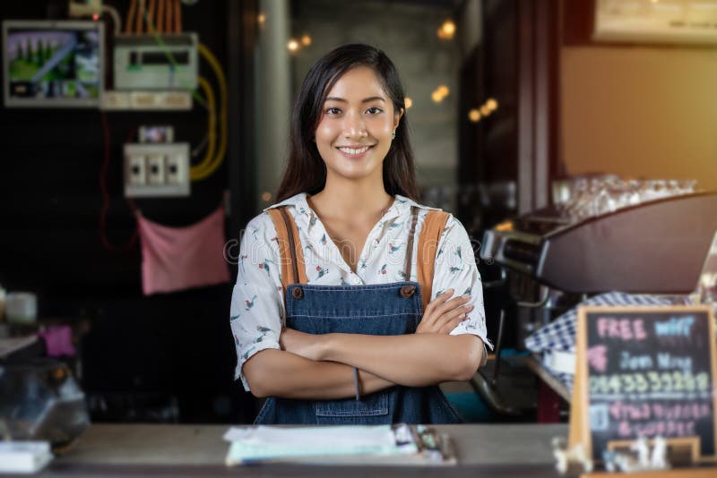 Asian women Barista smiling and using coffee machine in coffee shop counter - Working woman small business owner food and drink