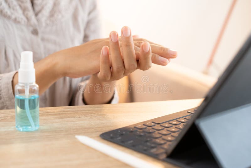 Asian women clean hand with alcohol sanitizer spray prevent the spread of germs and bacteria and avoid virus covid-19 before. Using her tablet at home royalty free stock image Asian women clean hand with alcohol sanitizer spray prevent the spread of germs and bacteria and avoid virus covid-19 before. Using her tablet at home royalty free stock image
