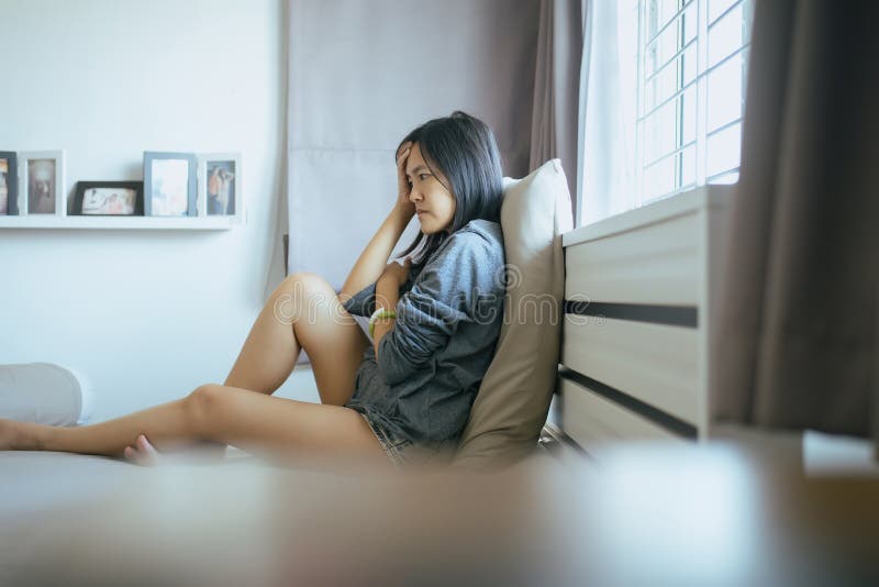 Asian women sitting on bedroom at home,Female feeling headache and confused problem in personal life,Contraception and unexpected
