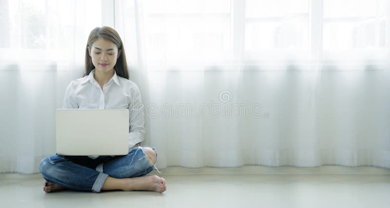 Asian women who are using a laptop in a warm house