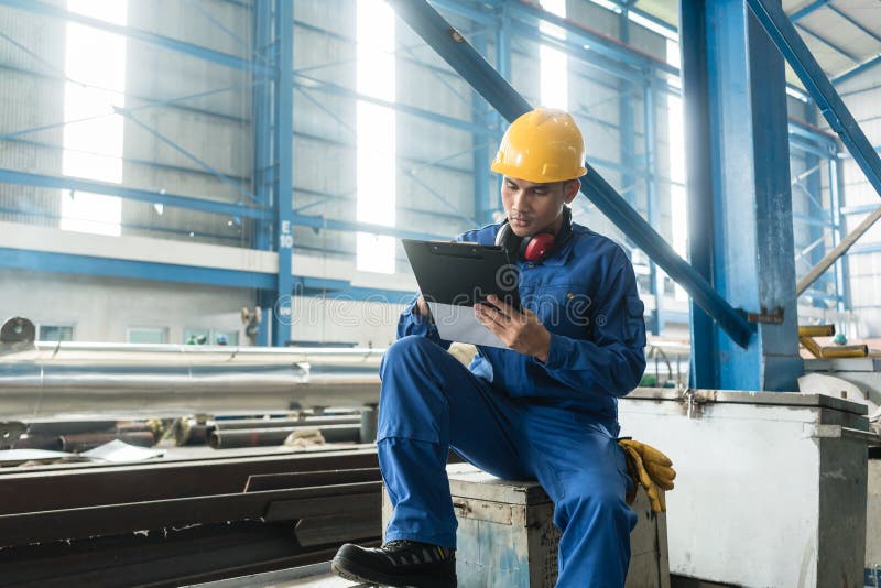 Asian worker writing observations about manufacturing stock photography Asian worker writing observations about manufacturing stock photography