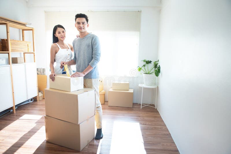 Asian young delivery man holding and carrying two cardbox standing in workplace.