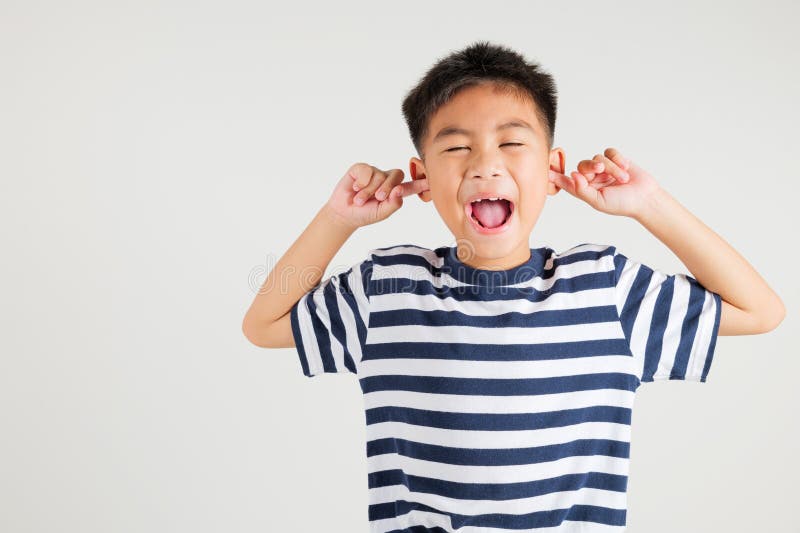 Asian young kid boy expression of pain and frustration is evident as she covers stock photos