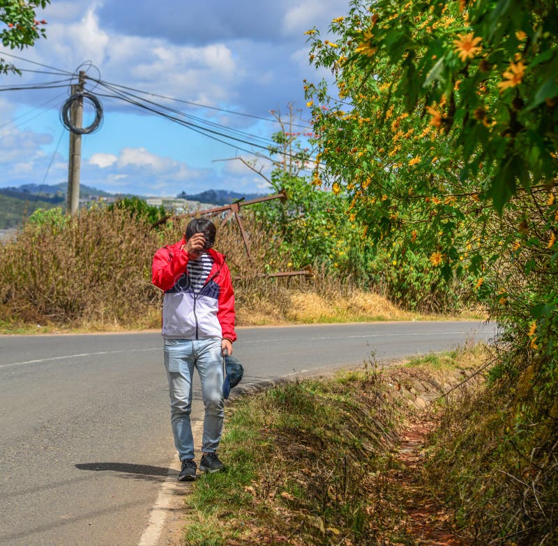 An Asian young man walking on rural road royalty free stock photos An Asian young man walking on rural road royalty free stock photos