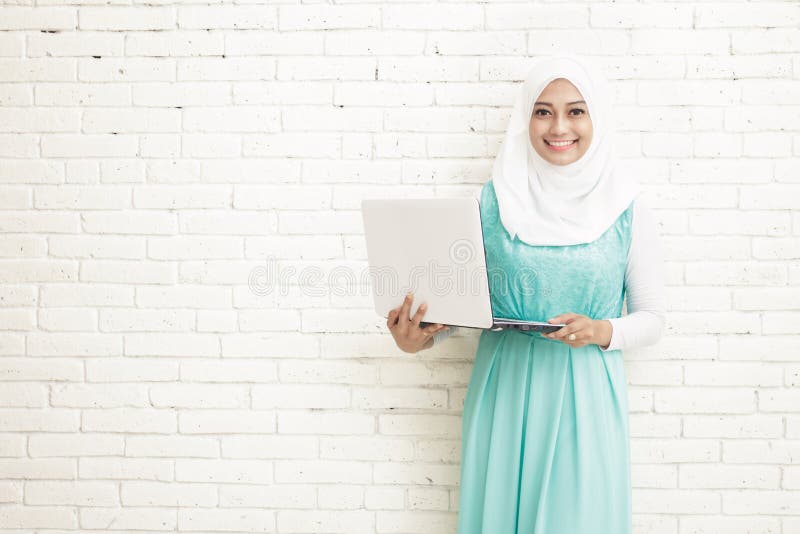 asian young woman wearing hijab holding a laptop stock images asian young woman wearing hijab holding a laptop stock images