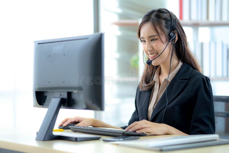 Asian young woman working in call centre. Young friendly operator woman agent with headsets working in a call centre