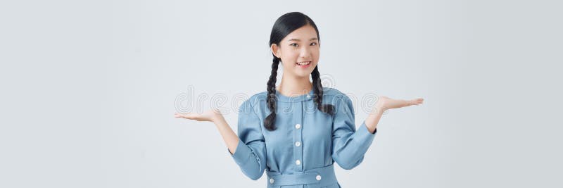 Asianisches süßes Mädchen lächelt und zeigt Hand zu präsentieren etwas isoliert auf weißem Hintergrund stockfotografie