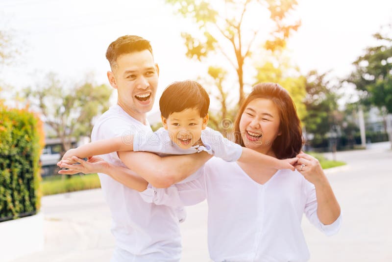 Asiatische Familie, die Spaß hat und öffentlich einen Kinderpark trägt lizenzfreie stockfotografie Asiatische Familie, die Spaß hat und öffentlich einen Kinderpark trägt lizenzfreie stockfotografie