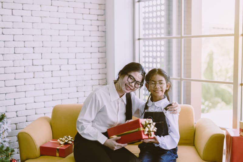 Asiatische Frau schenkt der jüngeren Schwester zu Hause eine Weihnachtsgeschenke, glücklich und lächelnd stockfotografie Asiatische Frau schenkt der jüngeren Schwester zu Hause eine Weihnachtsgeschenke, glücklich und lächelnd stockfotografie