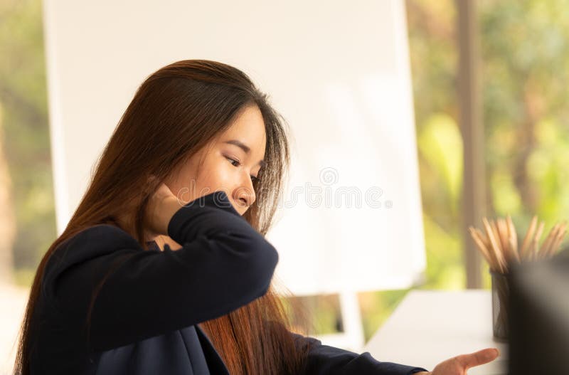 Asiatische Geschäftsfrau, die ihre Handgelenkschmerz vom Funktionieren hält stockfotografie