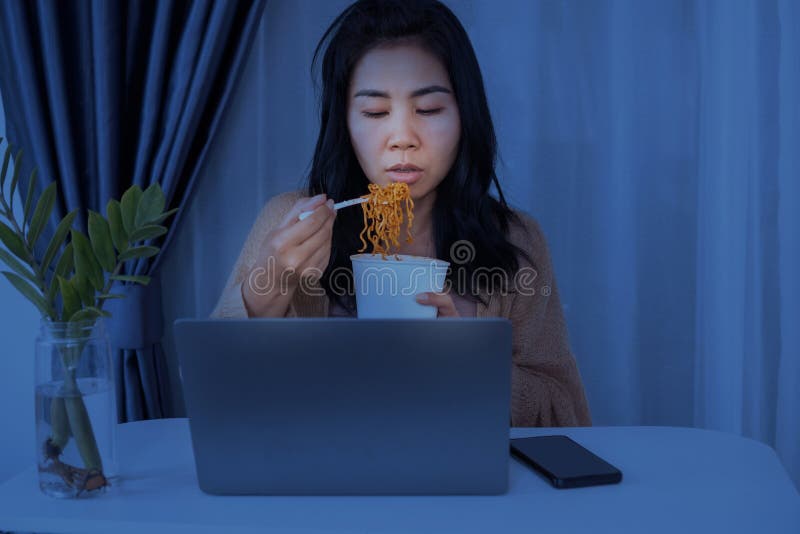 Asian businesswomen eating noodles late night stay up to work. Asian businesswomen eating noodles late night stay up to work