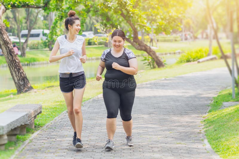 Asiatische jugendlich laufende fette und dünne rüttelnde Freundschaft