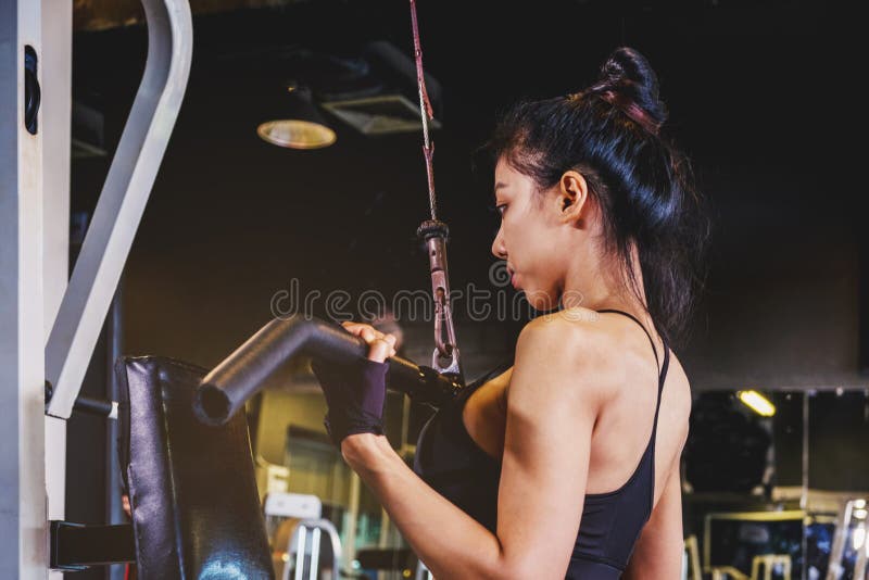 Asiatische junge Eignungsfrau führen Übung mit Übungmaschine durch lizenzfreie stockfotografie Asiatische junge Eignungsfrau führen Übung mit Übungmaschine durch lizenzfreie stockfotografie