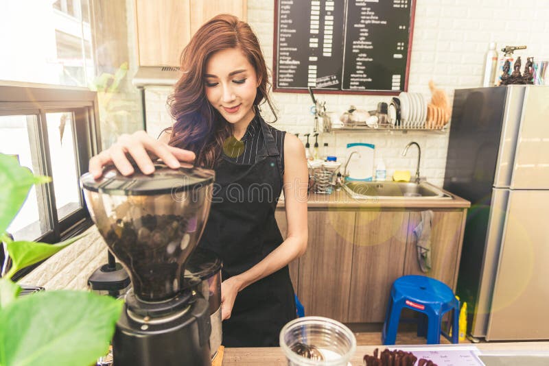 Asiatische Kaffeemaschinefrau, die Kaffee in der Kaffeestube macht Schönheit lizenzfreie stockfotos Asiatische Kaffeemaschinefrau, die Kaffee in der Kaffeestube macht Schönheit lizenzfreie stockfotos