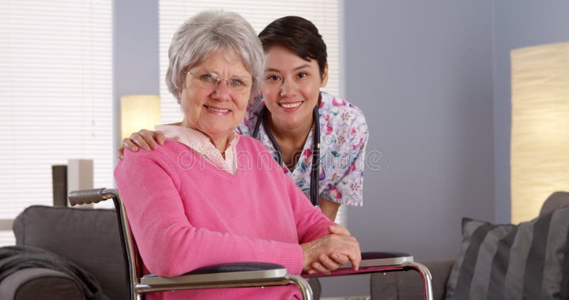 Asiatische Krankenschwester, die mit älterem Patienten lächelt stockbild Asiatische Krankenschwester, die mit älterem Patienten lächelt stockbild