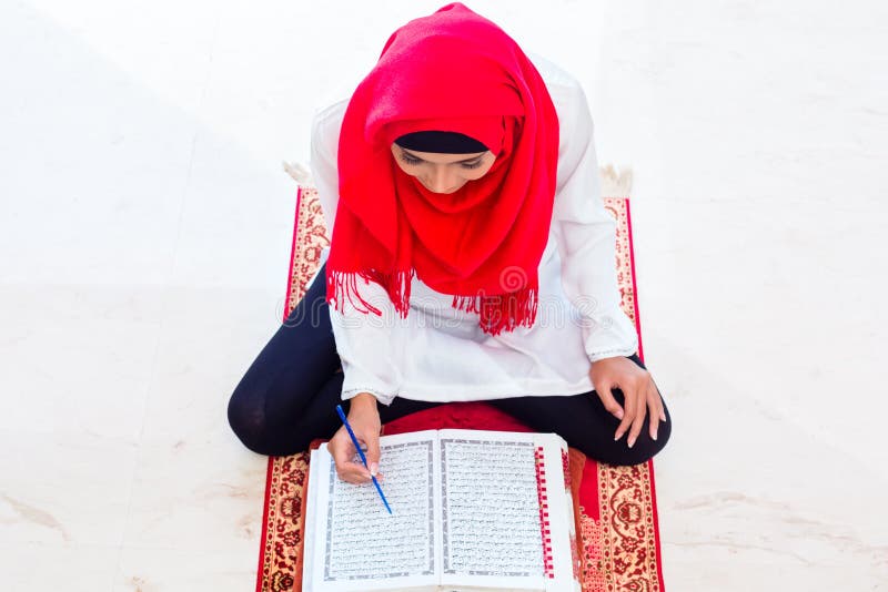 Asiatische moslemische Frau, die den Koran oder Quran studiert lizenzfreies stockbild Asiatische moslemische Frau, die den Koran oder Quran studiert lizenzfreies stockbild