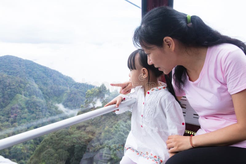 Asiatische Mutter- und Tochterreitdrahtseilbahn lizenzfreie stockbilder Asiatische Mutter- und Tochterreitdrahtseilbahn lizenzfreie stockbilder