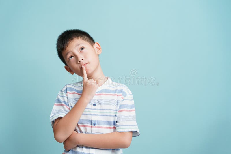 Asian little boy standing thinking on blue background isolated, Asia man look up and copy space. Asian little boy standing thinking on blue background isolated, Asia man look up and copy space.