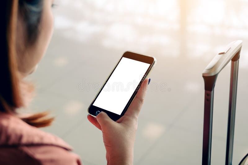 Asiatische touristische Frauenhände, die Smartphone mit Warteflug des leeren Bildschirms im Flughafenaufenthaltsraum halten und v stockbild Asiatische touristische Frauenhände, die Smartphone mit Warteflug des leeren Bildschirms im Flughafenaufenthaltsraum halten und v stockbild