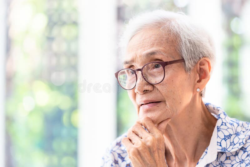 Asiatische ältere Frau in den Gläsern, denkend mit der Hand auf Kinn in ihrem Haus, lächelndes Gefühl der älteren Frau glücklich stockfotos Asiatische ältere Frau in den Gläsern, denkend mit der Hand auf Kinn in ihrem Haus, lächelndes Gefühl der älteren Frau glücklich stockfotos
