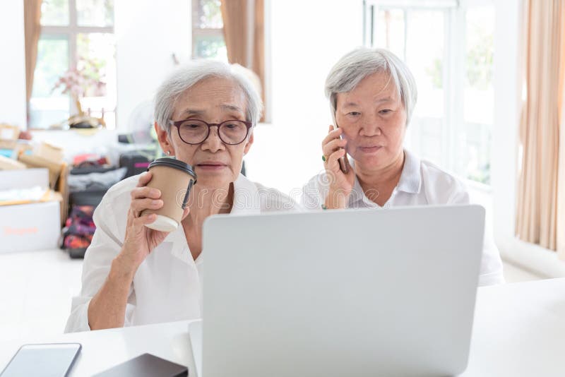 Asiatische ältere Frau und Freund mit Laptop-Computer, ältere Menschen, die etwas interessant beim Halten des Telefons, sprechend stockfotografie Asiatische ältere Frau und Freund mit Laptop-Computer, ältere Menschen, die etwas interessant beim Halten des Telefons, sprechend stockfotografie