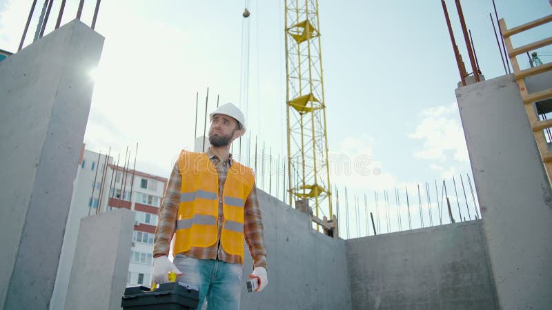 Asiatischer Architekt in harter Hand mit Blick auf die intelligente Uhr bei der Renovierung des Gebäudes stock video footage