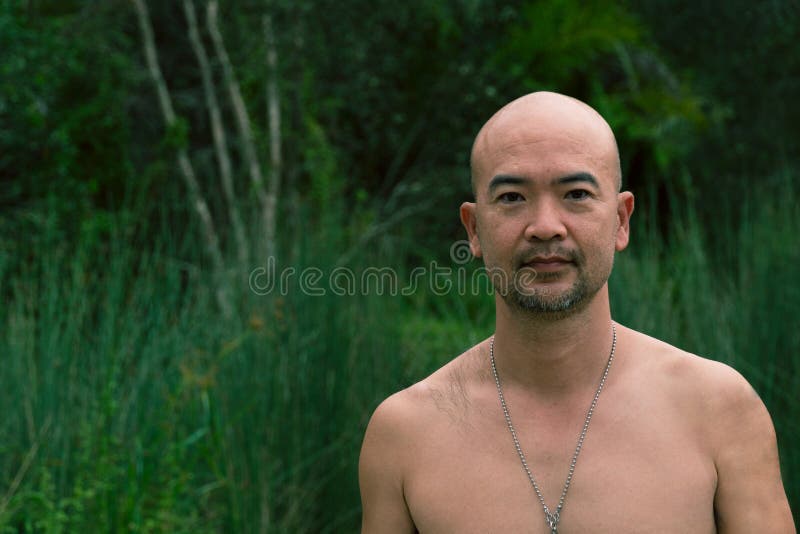 Asiatischer Japanische Nirgendwo Mann des Bartes Vierzigern mit dunkelgrünem Waldnaturhintergrund stockbild