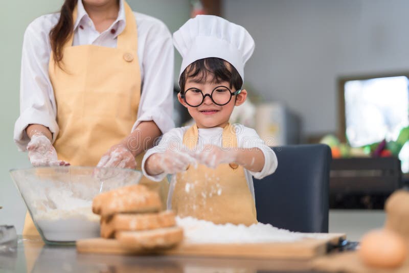 Asiatischer kleiner Junge des Patissiers, der Bäckereibrotplätzchen und -kuchen köstliche süße Nahrung macht lizenzfreies stockfoto Asiatischer kleiner Junge des Patissiers, der Bäckereibrotplätzchen und -kuchen köstliche süße Nahrung macht lizenzfreies stockfoto