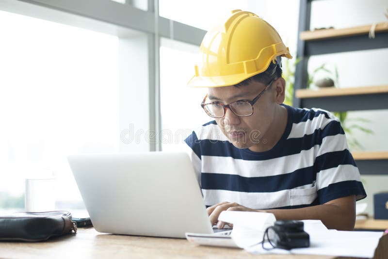 Asiatischer Manningenieur benutzt Laptop für das Arbeiten lizenzfreies stockfoto Asiatischer Manningenieur benutzt Laptop für das Arbeiten lizenzfreies stockfoto