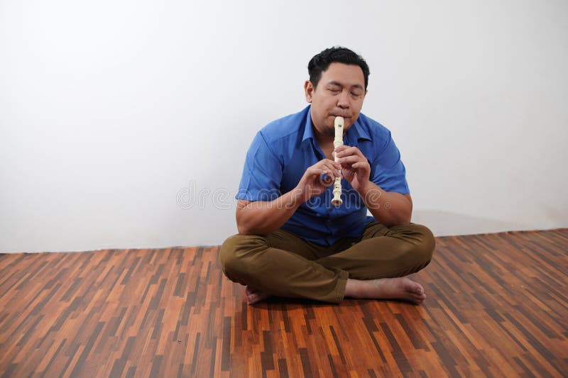 Asiatischer Mann spielt Blockflöte, Musikinstrument stockfotografie