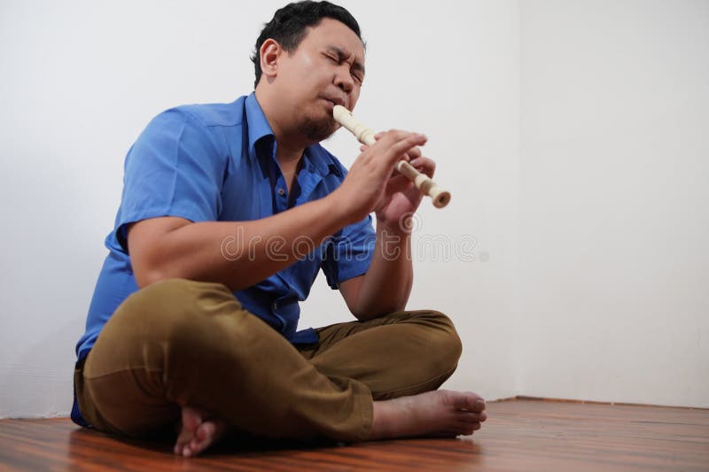 Asiatischer Mann spielt Blockflöte, Musikinstrument stockfotografie