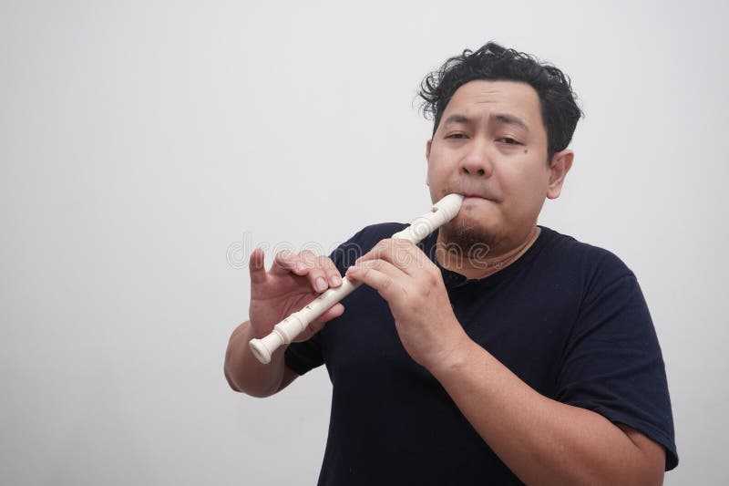 Asiatischer Mann spielt Blockflöte, Musikinstrument stockbild