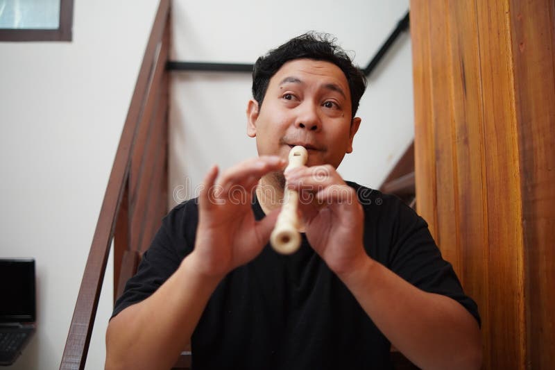 Asiatischer Mann spielt Blockflöte, Musikinstrument lizenzfreies stockfoto