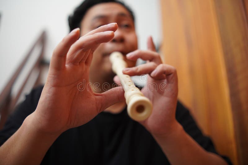 Asiatischer Mann spielt Blockflöte, Musikinstrument stockbilder