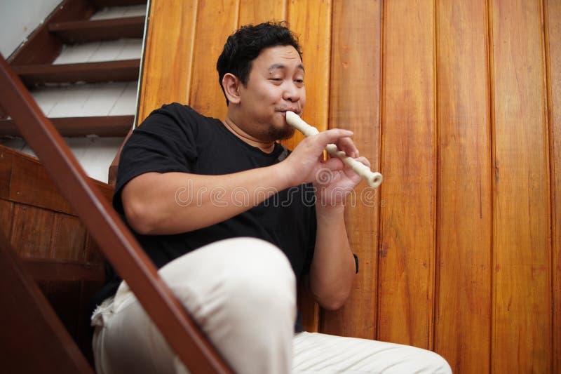 Asiatischer Mann spielt Blockflöte, Musikinstrument stockfotografie