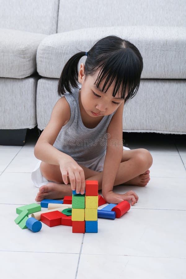 Asiatisches chinesisches kleines Mädchen, das Blöcke auf dem Boden spielt lizenzfreies stockfoto Asiatisches chinesisches kleines Mädchen, das Blöcke auf dem Boden spielt lizenzfreies stockfoto