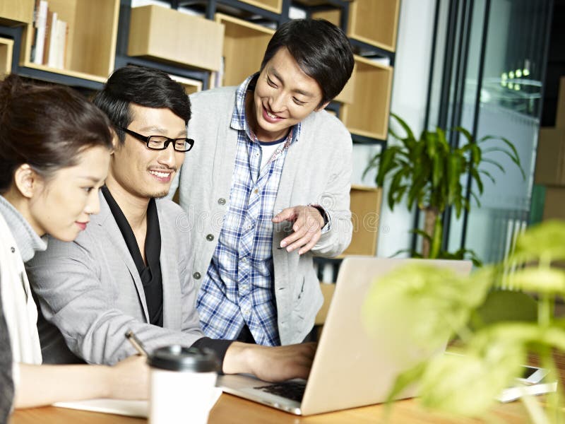 Asiatisches Geschäftsteam, das im Büro zusammenarbeitet stockbild Asiatisches Geschäftsteam, das im Büro zusammenarbeitet stockbild