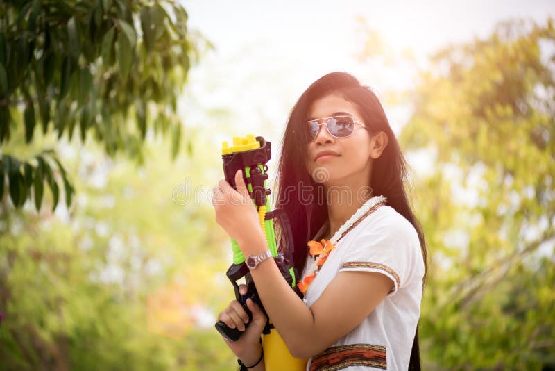 Asiatisches Mädchen der jungen glücklichen Schönheit mit tragendem Sommerhemd des Wasserwerfers in Songkran-Festival - Wasserf lizenzfreie stockfotografie Asiatisches Mädchen der jungen glücklichen Schönheit mit tragendem Sommerhemd des Wasserwerfers in Songkran-Festival - Wasserf lizenzfreie stockfotografie