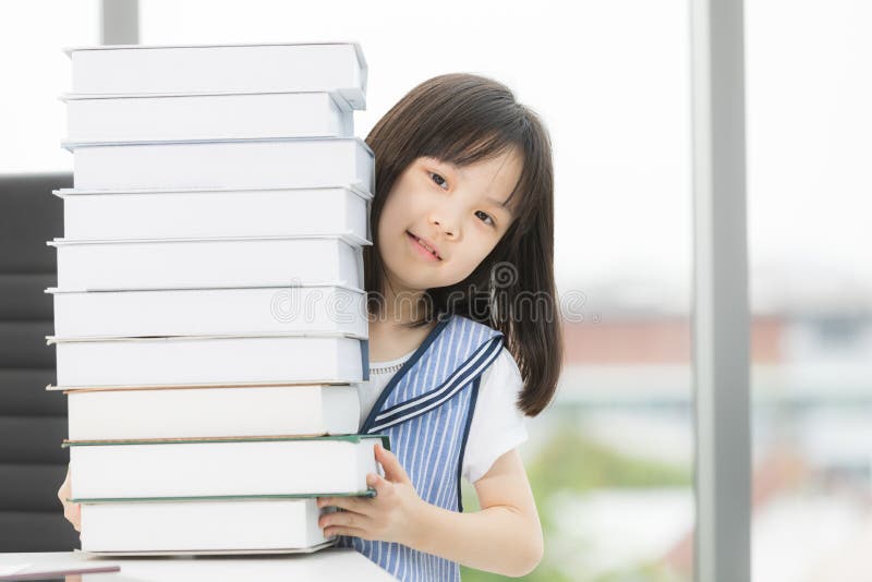 Asiatisches M?dchenl?cheln zur Kamera, sie bei Tisch sitzend stockfotos Asiatisches M?dchenl?cheln zur Kamera, sie bei Tisch sitzend stockfotos