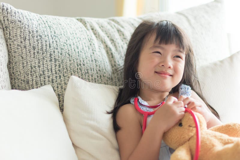 Asiatisches nettes kleines Mädchen ist lächelnd spielend und Doktor mit stetho stockbilder Asiatisches nettes kleines Mädchen ist lächelnd spielend und Doktor mit stetho stockbilder
