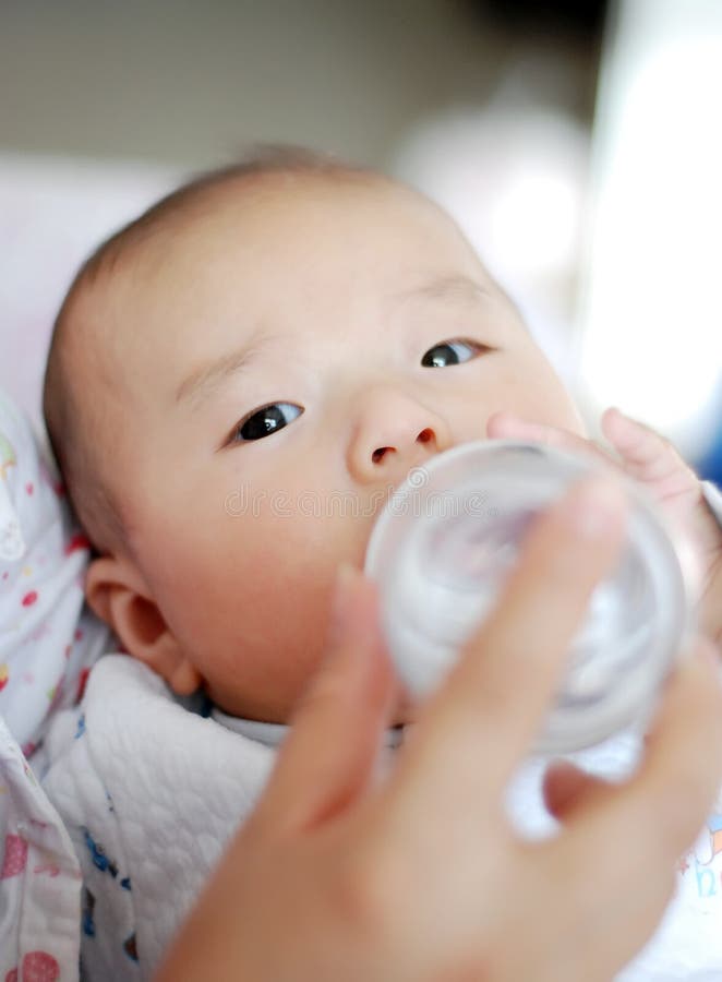 Asiatisches Schätzchen ist Trinkmilch stockbild Asiatisches Schätzchen ist Trinkmilch stockbild
