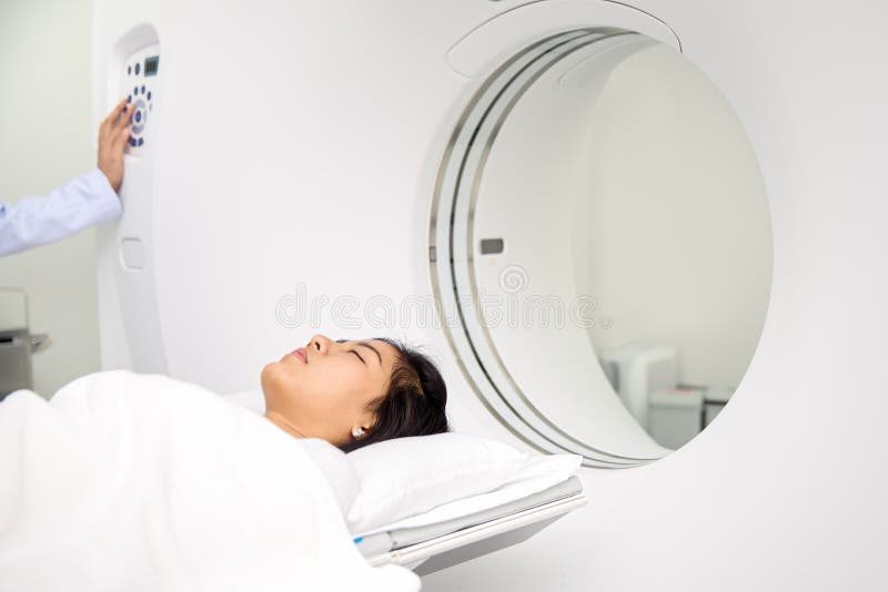 Asian lady sleep on a CT Scan bed and panel control by Radiologic technician. Asian lady sleep on a CT Scan bed and panel control by Radiologic technician