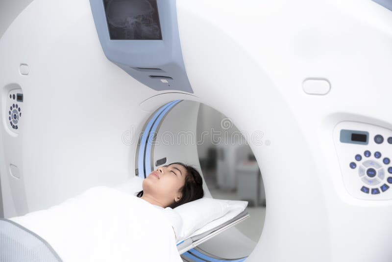 Asian lady sleep on a CT Scan bed and panel control by Radiologic technician. Asian lady sleep on a CT Scan bed and panel control by Radiologic technician