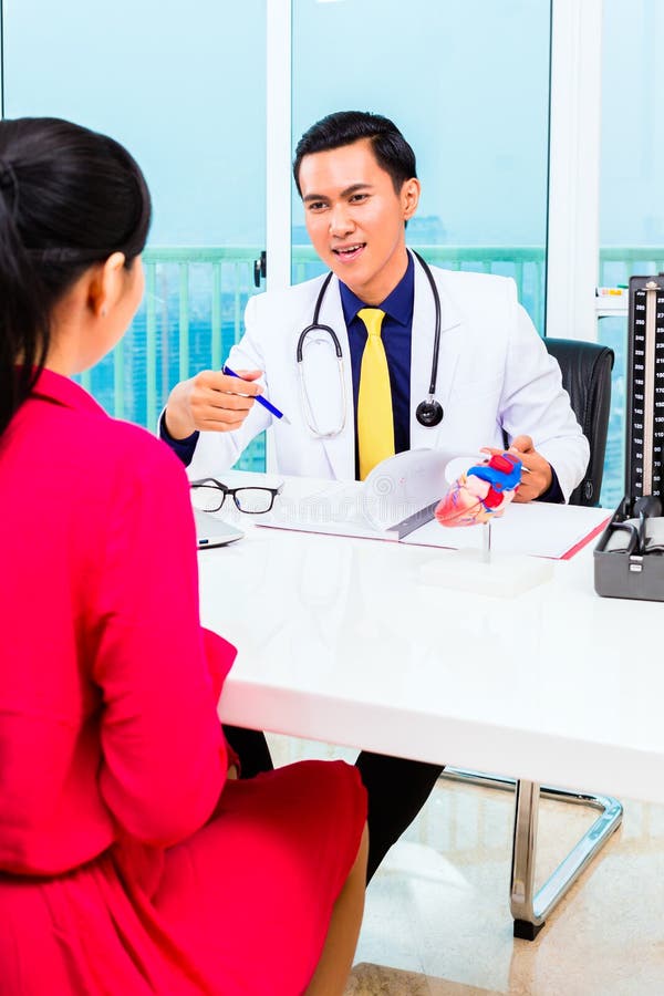 Asiatisk doktor med patienten i medicinsk kirurgi arkivbild Asiatisk doktor med patienten i medicinsk kirurgi arkivbild