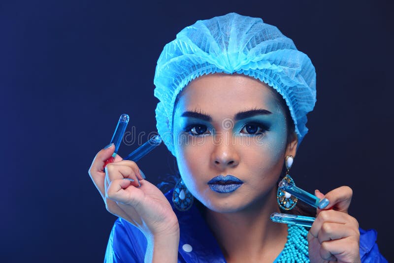 Asiatisk doktor Woman för kemi med provet för labb för modesminkinfall