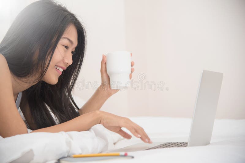 Asiatisk flicka för lycka som ler och rymmer koppen kaffe royaltyfria bilder Asiatisk flicka för lycka som ler och rymmer koppen kaffe royaltyfria bilder