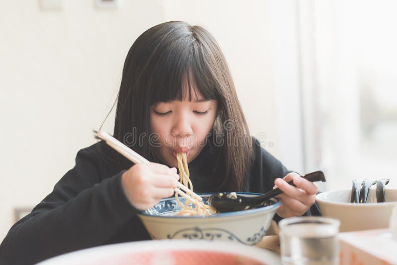 Asiatisk flicka som äter chashuramen i japansk restaurang arkivbilder Asiatisk flicka som äter chashuramen i japansk restaurang arkivbilder