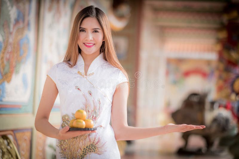 Asiatisk kinesisk kvinna i beträffande hållande orange lön för traditionell kines royaltyfri foto Asiatisk kinesisk kvinna i beträffande hållande orange lön för traditionell kines royaltyfri foto