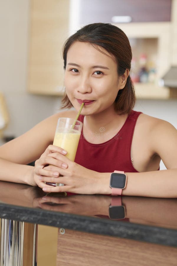 Asiatisk kvinna som dricker den smakliga fruktcoctailen fotografering för bildbyråer Asiatisk kvinna som dricker den smakliga fruktcoctailen fotografering för bildbyråer